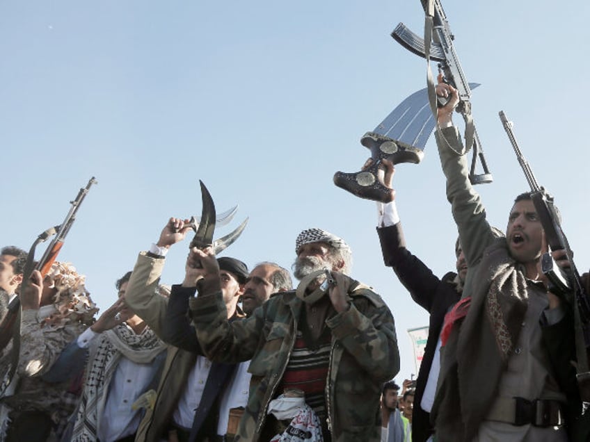 Yemen's Houthi followers brandish weapons and chant slogans as they take part in a pr