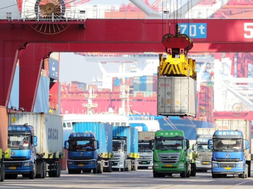 A bridge crane is grabbing containers at the Qianwan Joint Container Terminal in Qingdao Port, in Qingdao, China, on January 25, 2024. In 2023, the container throughput of Qingdao Port in Shandong province exceeded 30 million TEUs. (Photo by Costfoto/NurPhoto via Getty Images)