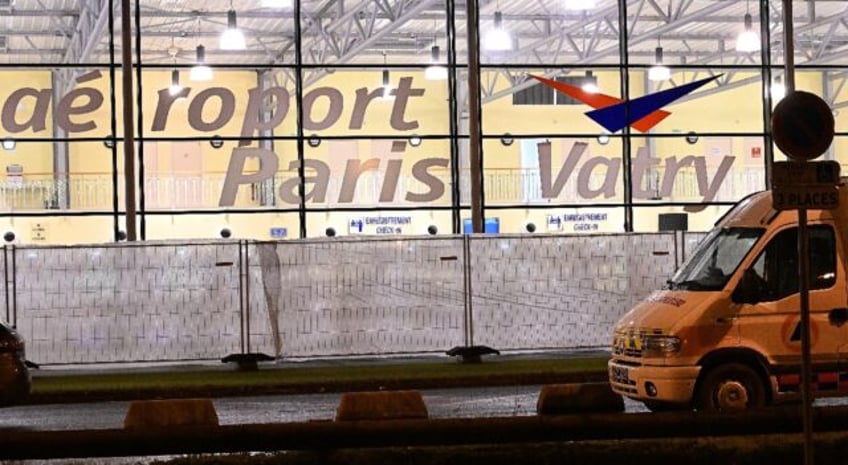 A civil protection vehicle parked outside the airport where the plane is parked