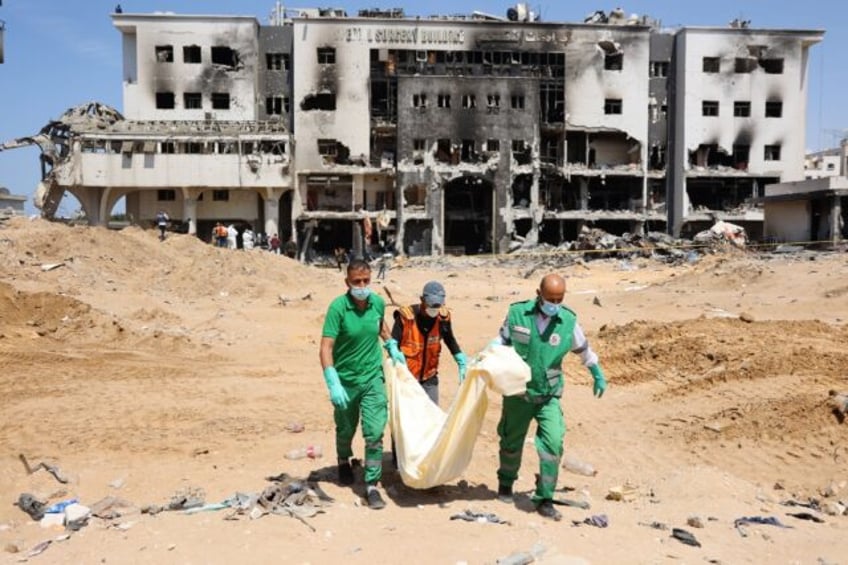 Palestinian forensic and civil defence workers recover human remains from the grounds of A