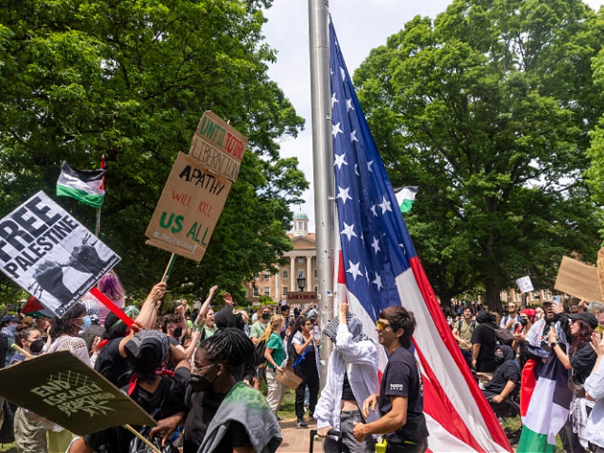 Pro-Palestinian demonstrators replace an American flag with a Palestinian flag Tuesday, April 30, 2024 at UNC-Chapel Hill. Police removed a "Gaza solidarity encampment" earlier Tuesday morning. (Travis Long/News & Observer/Tribune News Service via Getty Images)