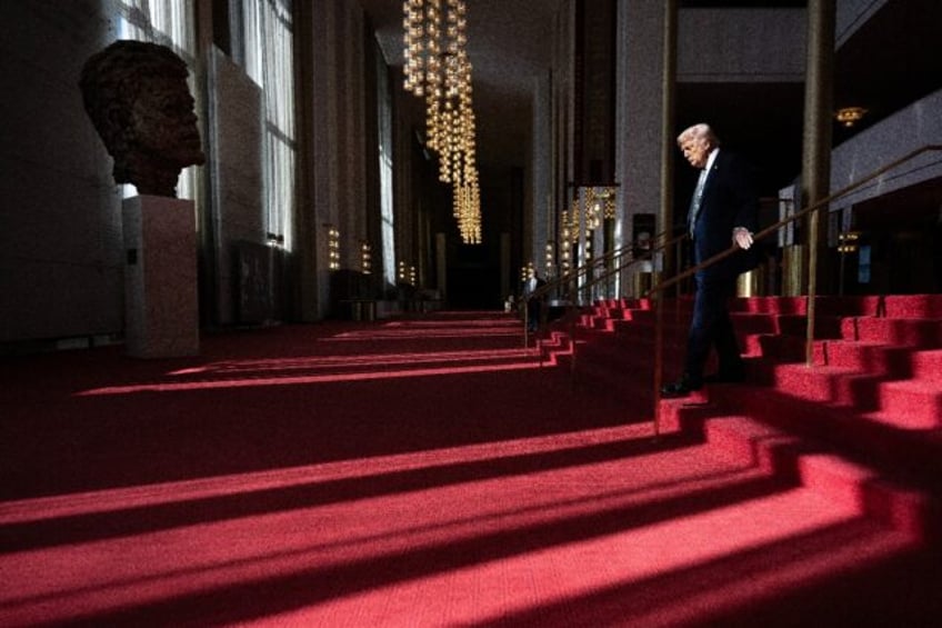 US President Donald Trump walks though the Hall of Nation as he visits the John F. Kennedy