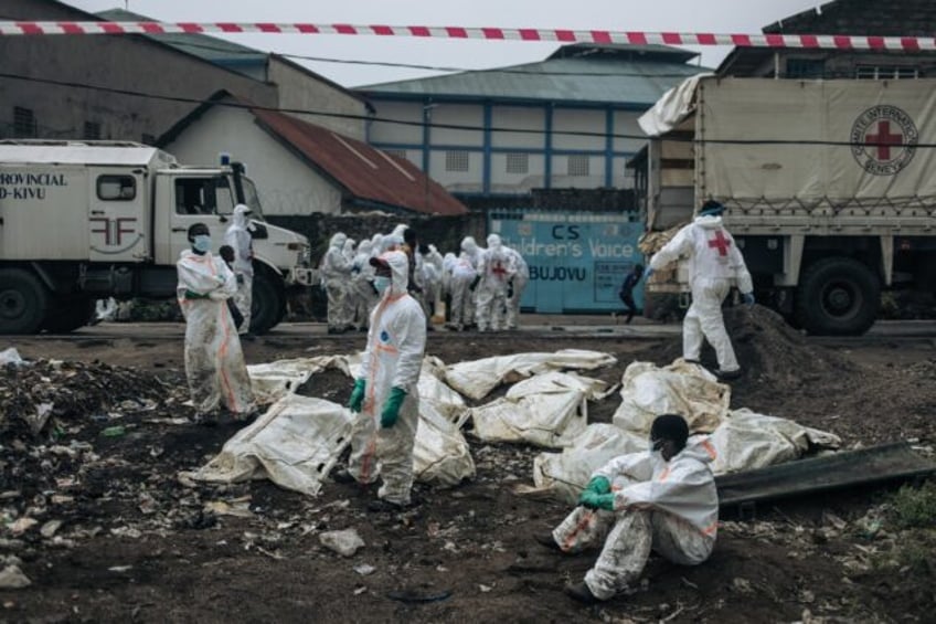 Members of the Congolese Red Cross and Civil Protection rest after burying victims of the