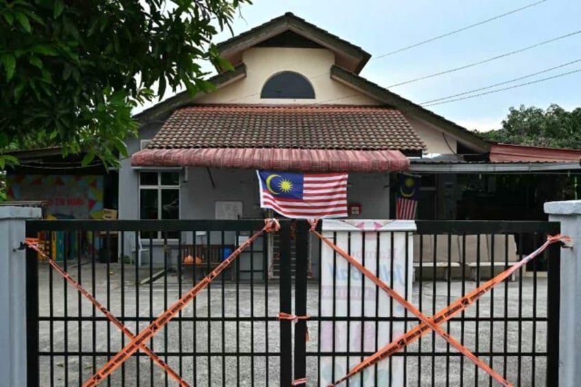 Malaysian Department of Social Welfare tape blocks off gates at the entrance to a care hom