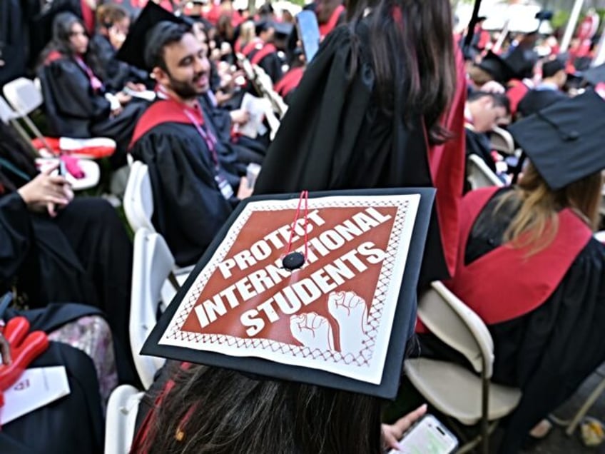 CAMBRIDGE, MA - MAY 29: A Harvard University graduate with a message in support of interna
