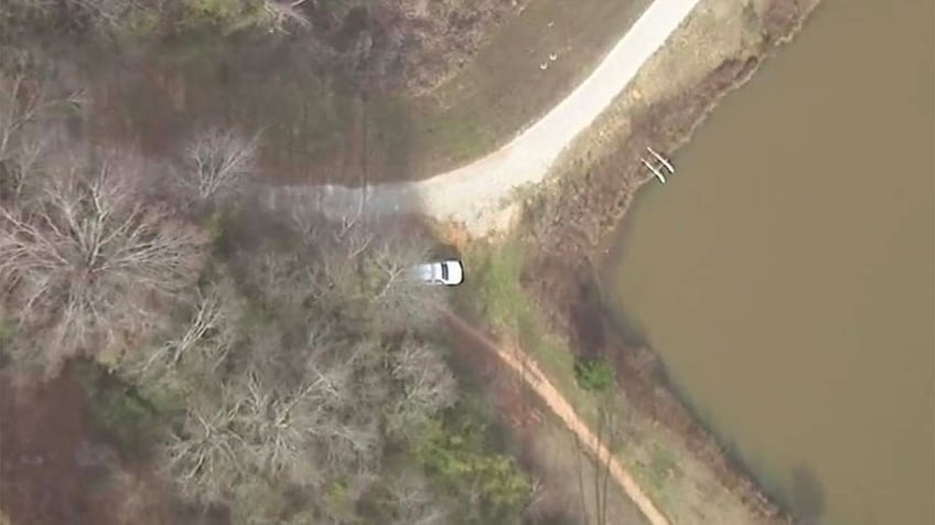 An aerial view of a wooded area behind Lake Herrick