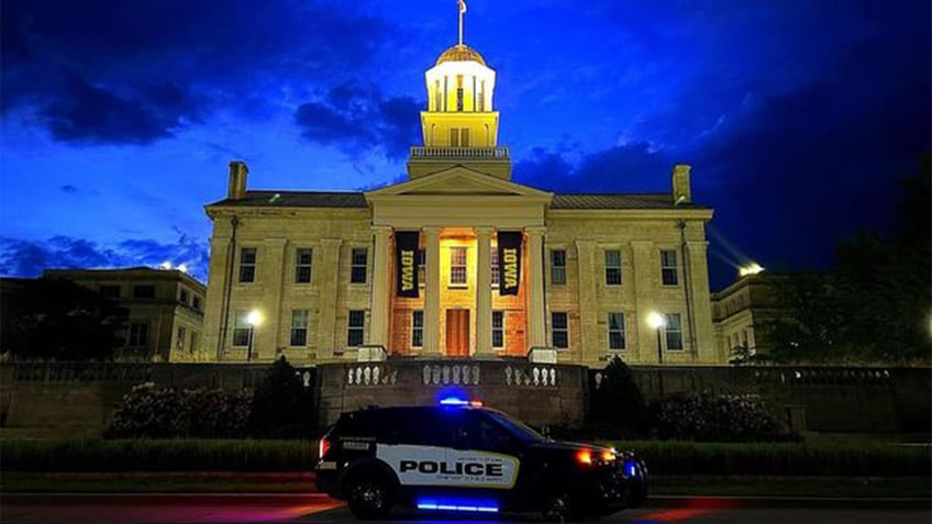 University of Iowa police car in front of campus building