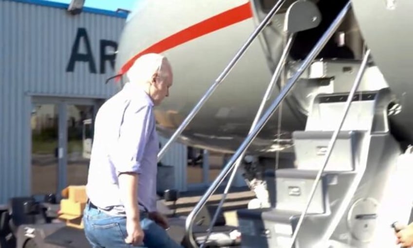 Wikileaks founder Julian Assange walking to board a plane from London, released from a hig