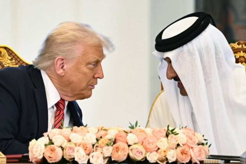 Qatar's Emir Sheikh Tamim bin Hamad al-Thani (R) and US President Donald Trump speak to ea