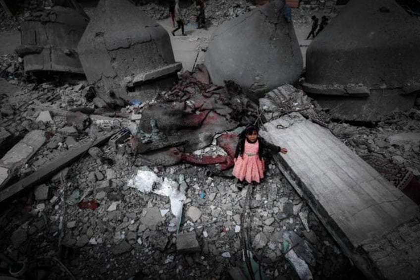 A Palestinian girl stands in the ruins of the Al-Faruq Mosque in Rafah on Friday