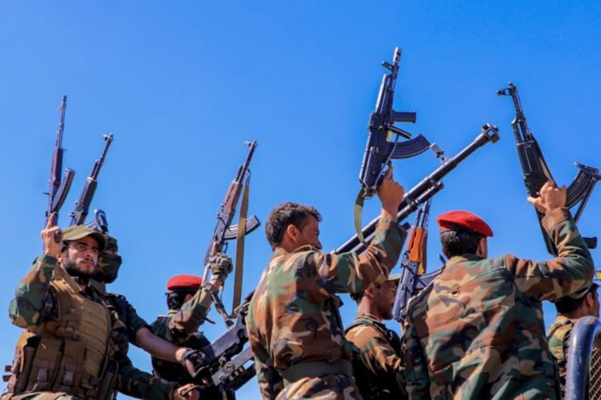 Huthi fighters brandish weapons as they rally during an anti-Israel and anti-US rally in Yemen's Huthi-controlled capital Sanaa on January 22, 2024