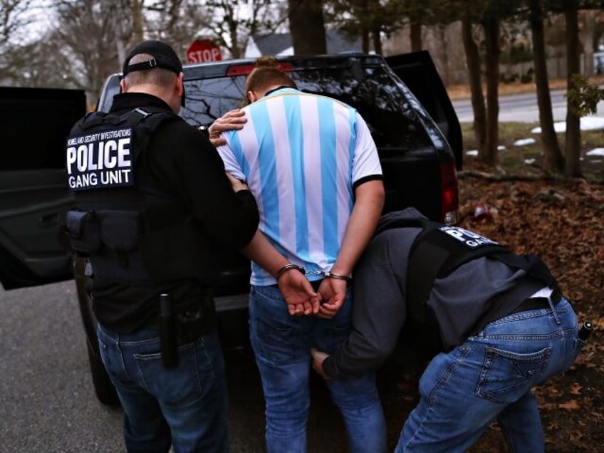 Homeland Security Investigations (HSI) ICE agents frisk a suspected MS-13 gang member and