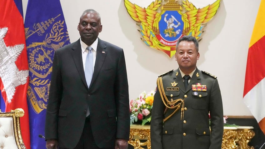 U.S. Defense Secretary Lloyd Austin poses for photographs with Cambodian Defense Minister Tea Seiha at the Defense Ministry in Phnom Penh, Cambodia