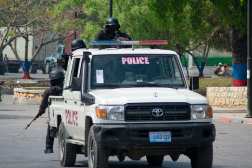 Armed police officers monitor the area after gang violence in the neighborhood on the even