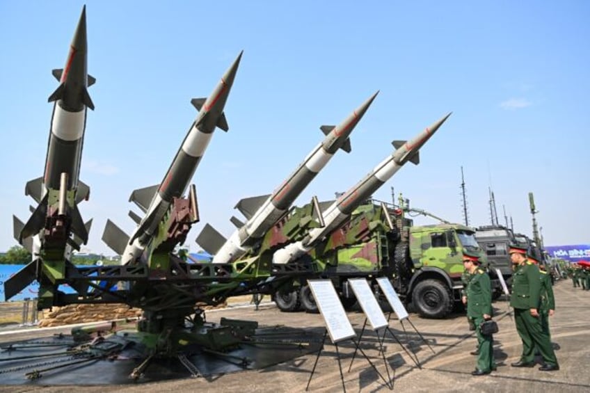 Vietnamese military officials look at an anti-aircraft missile launcher and ammunition dur