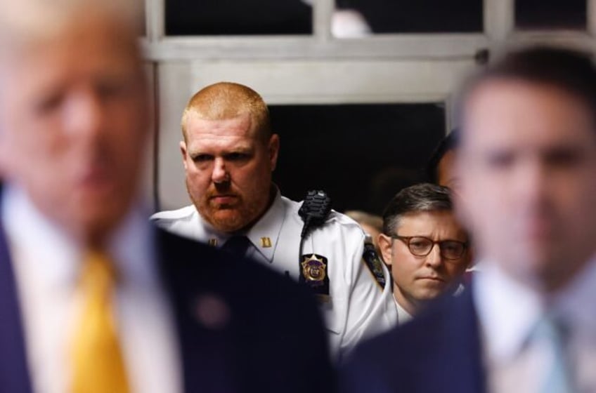 US Speaker of the House Mike Johnson (second R) listens as former president Donald Trump (