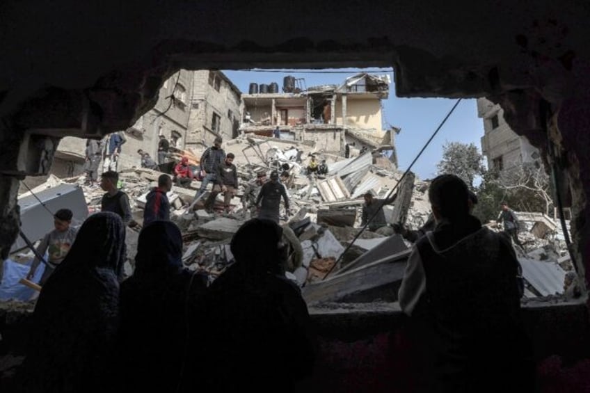 Palestinians check the rubble of buildings that were destroyed following overnight Israeli