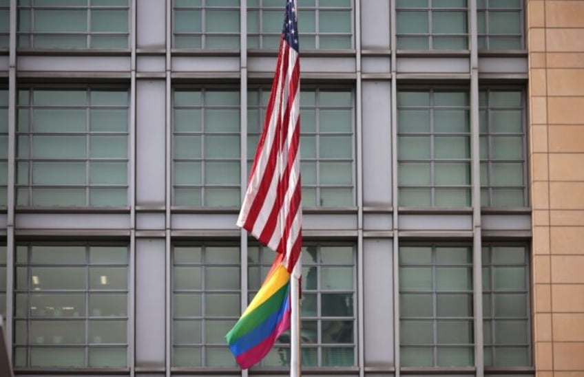 The rainbow flag flies under the US flag at the entrance to the US embassy in Moscow in Ju
