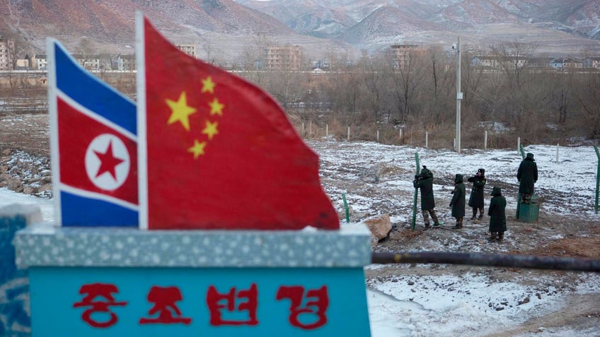 Chinese paramilitary policemen build a fence at a crossing in the Chinese border town of Tumen