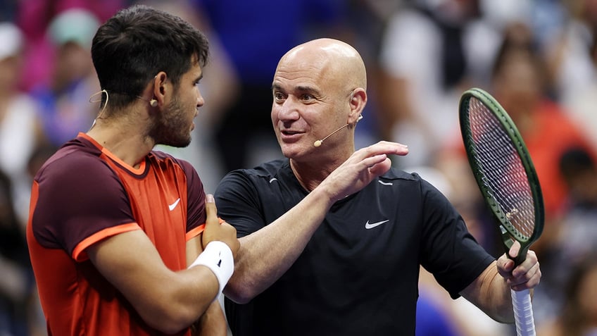 Andre Agassi talks with Carlos Alcaraz