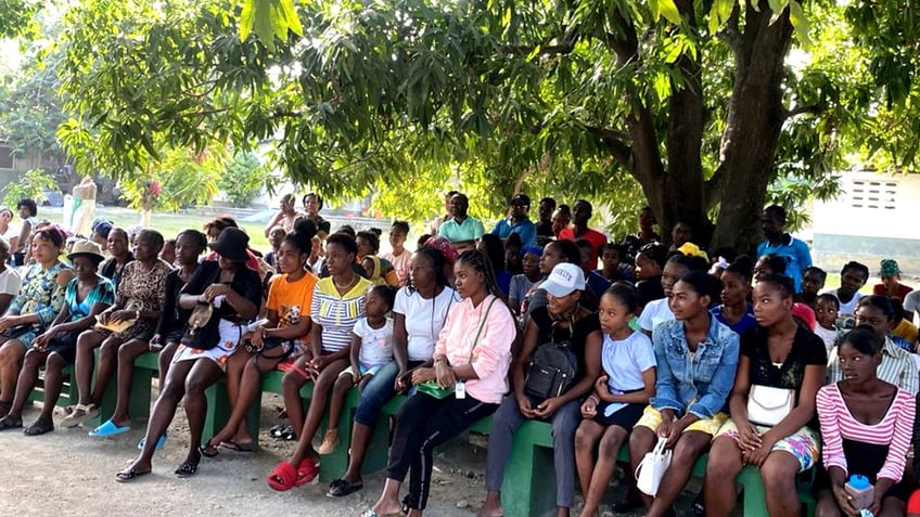 Haitians sit outside
