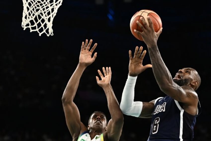 LeBron James of the United States drives to the basket against Georginho De Paula in the U