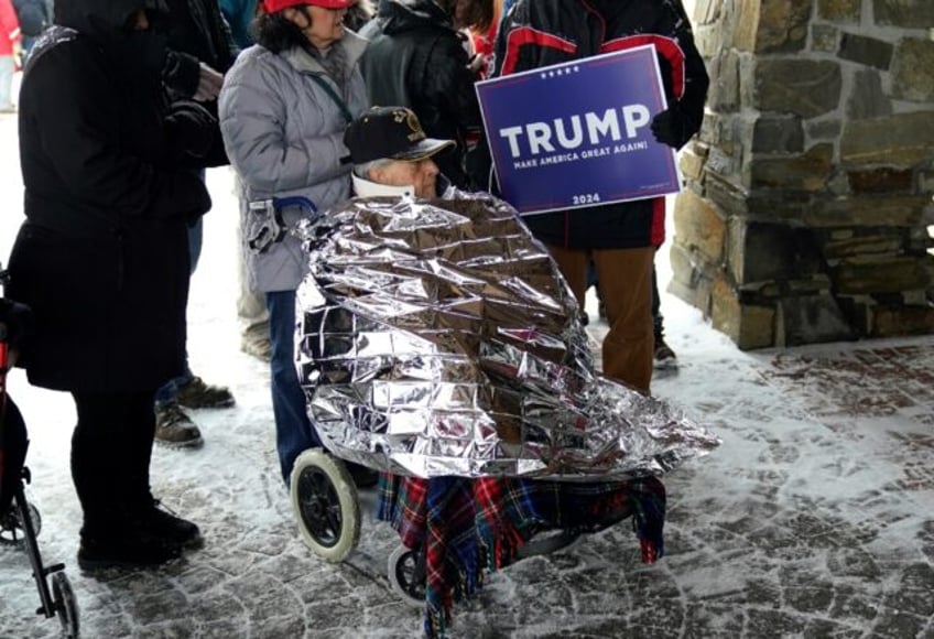 Donald Trump supporters bundle up in the winter cold waiting to attend rally for the Republican front-runner on January 16, 2024, in Atkinson, New Hampshire