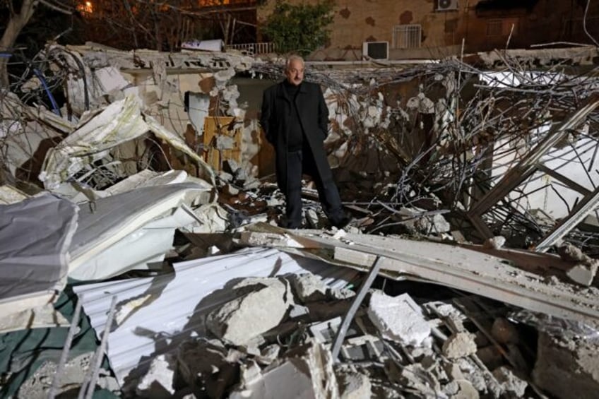 Palestinian activist Fakhri Abu Diab stands amid the rubble of his home that was demolishe