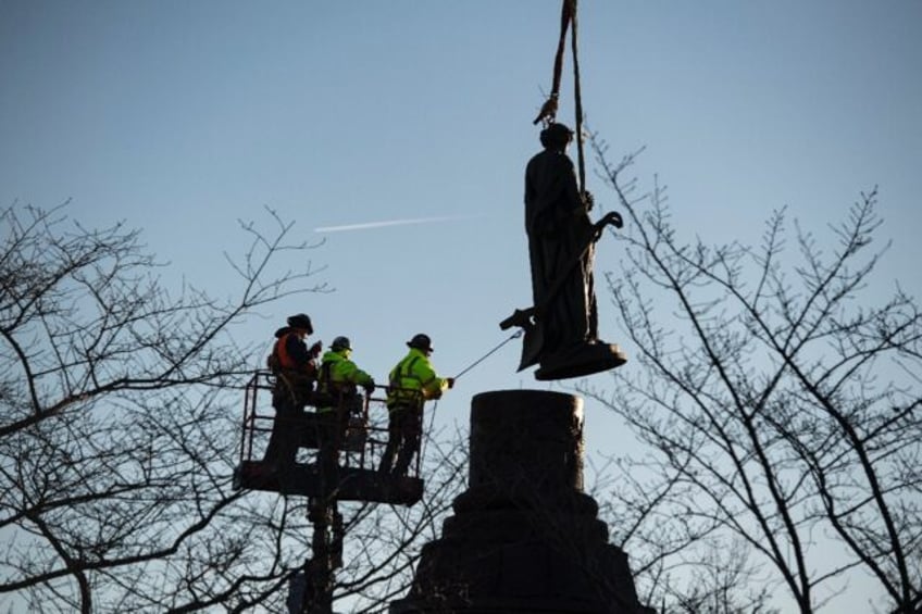 Workers remove a statue from atop the Confederate Memorial at Arlington National Cemetery in Virginia on December 20, 2023