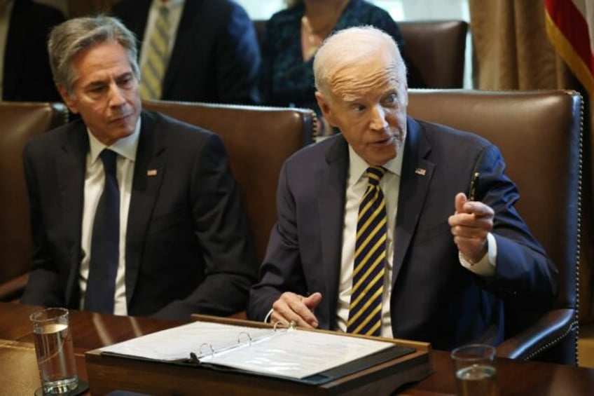 US President Joe Biden sits next to Secretary of State Antony Blinken, who will fill in f