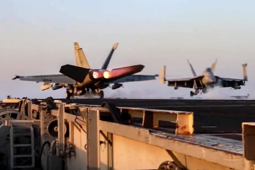 US Navy F/A-18 fighter aircraft operate on an aircraft carrier at sea reportedly during op