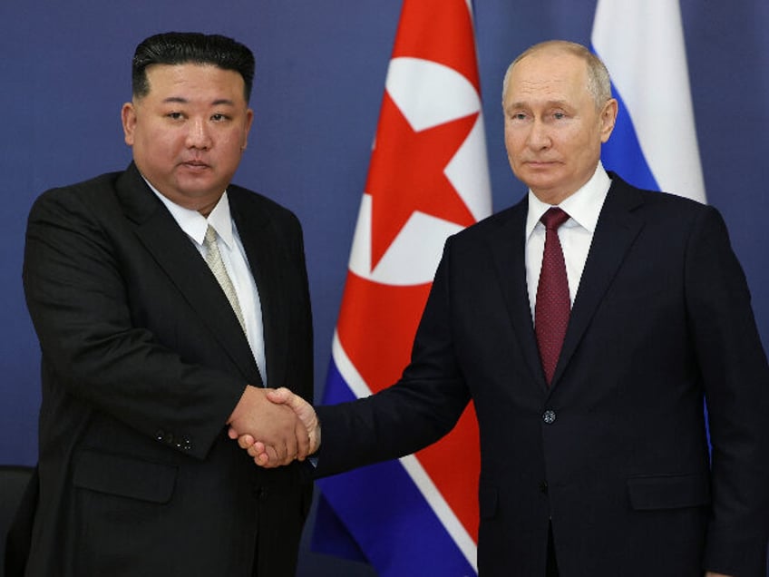 Russian President Vladimir Putin, right, and North Korea's leader Kim Jong Un shake h