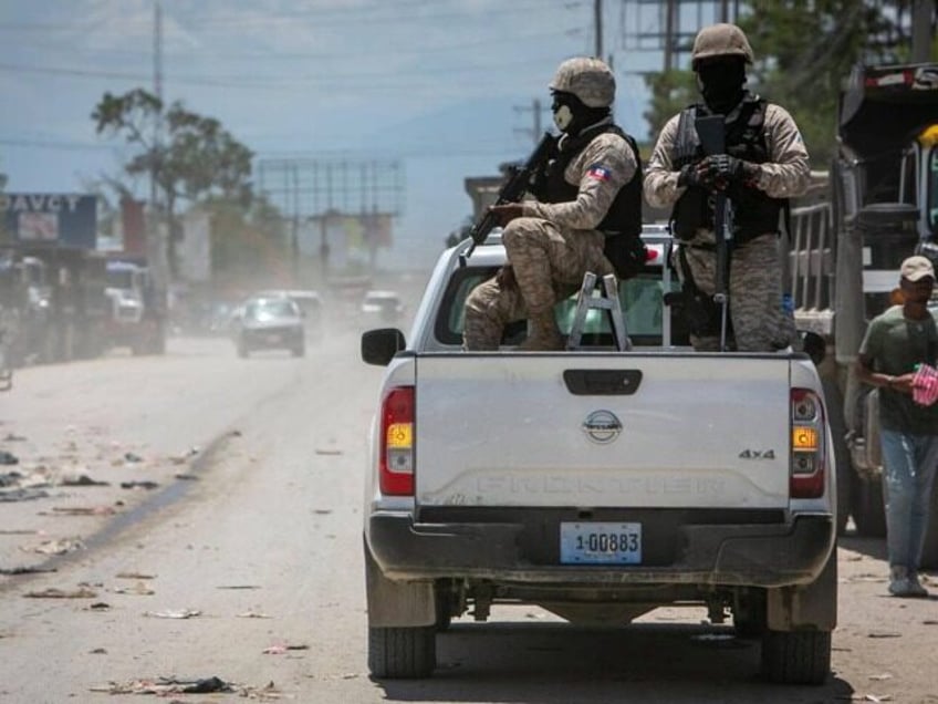 Haiti police on patrol keep their eyes on traffic during a stop at a police checkpoint in