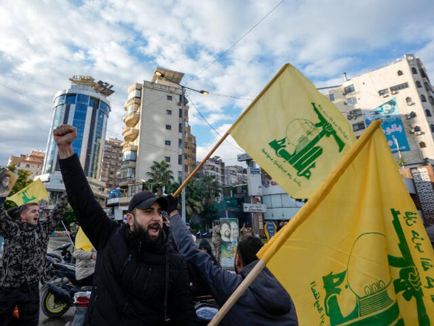 Residents celebrate carrying Hezbollah's flags in Dahiyeh, Beirut, Lebanon, following a ce