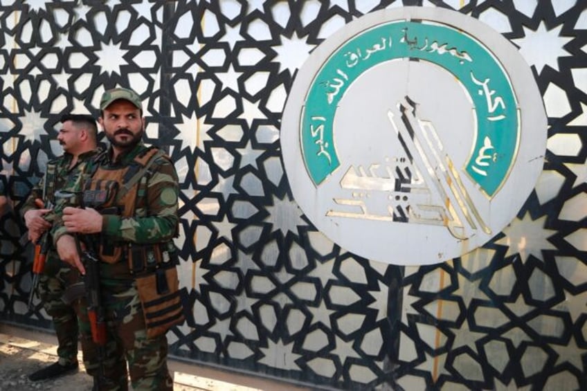 Members of Iraq's Hashed al-Shaabi stand guard at the entrance of their headquarters in Baghdad