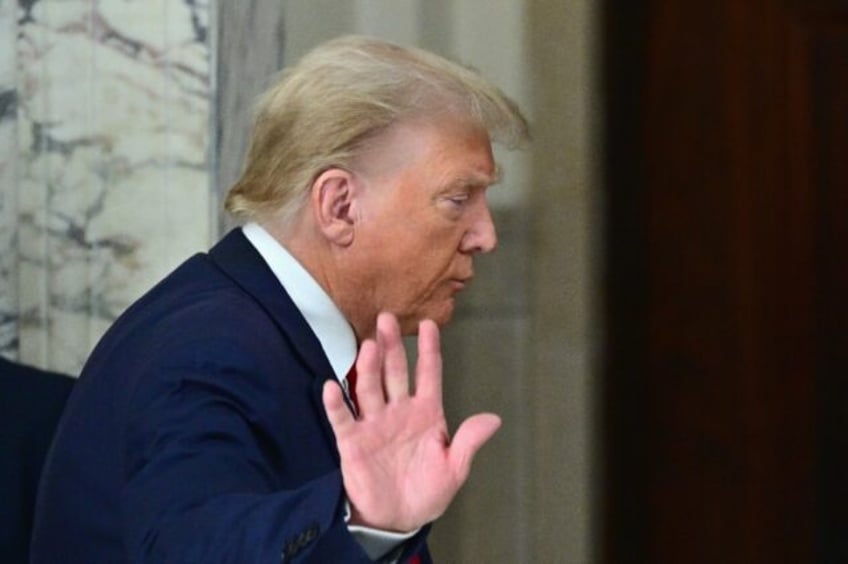 Former US president Donald Trump waves after speaking to the media during his civil fraud