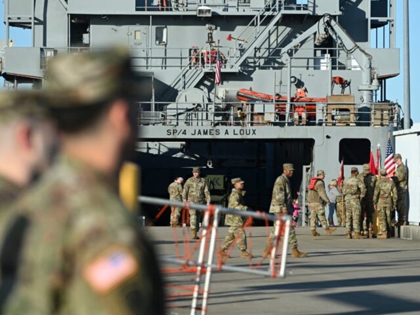 Crew members of the USAV SP4 James A. Loux stand near the vessel before it sails off the p