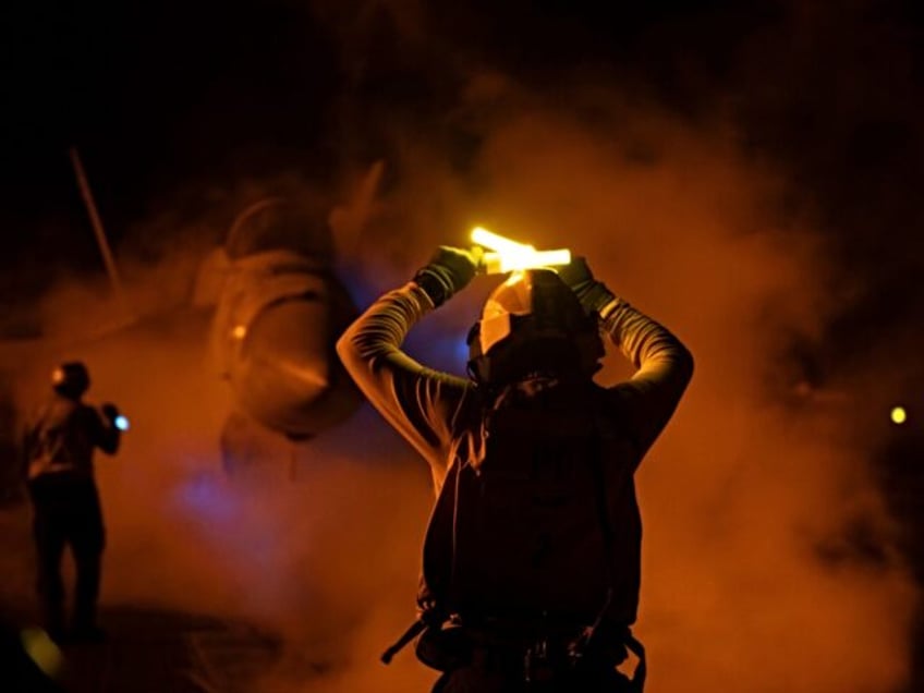 UNSPECIFIED, YEMEN - JANUARY 23: (----EDITORIAL USE ONLY MANDATORY CREDIT - ' USCENTCOM / HANDOUT' - NO MARKETING NO ADVERTISING CAMPAIGNS - DISTRIBUTED AS A SERVICE TO CLIENTS----) A staff holds the light to pass the military aircrafts as U.S. Central Command forces alongside UK Armed Forces, and with the …