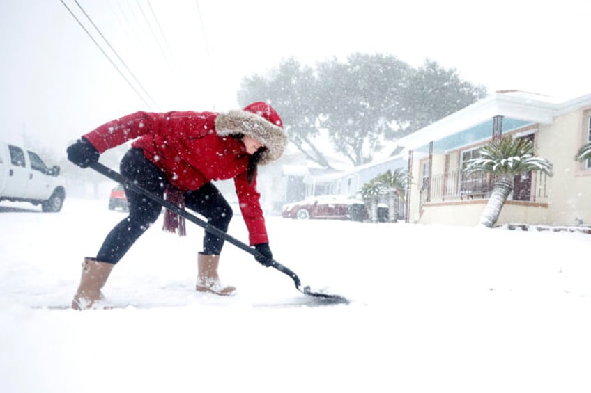 NEW ORLEANS, LOUISIANA - JANUARY 21: A woman shovels snow from her driveway in the Gentill