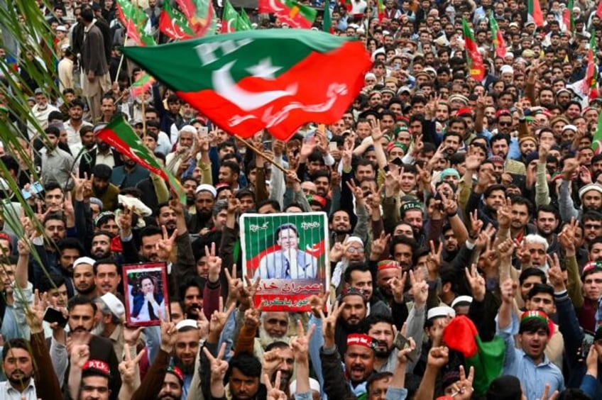 Pakistan Tehreek-e-Insaf (PTI) party supporters hold portraits of former prime minister Im