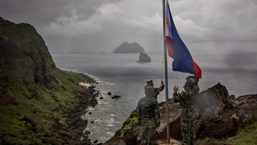 Filipino soldiers take part in a flag raising ceremony