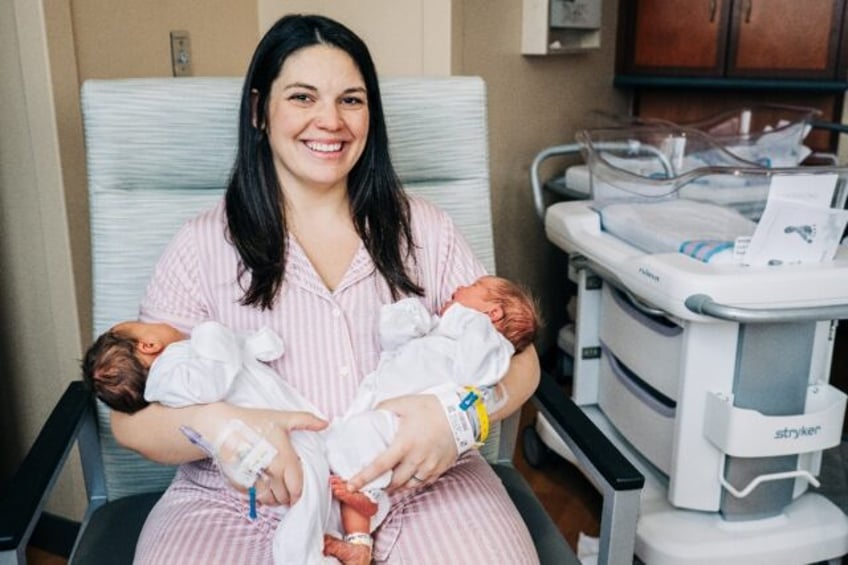 In this December 21, 2023, handout photo from the University of Alabama at Birmingham, Kelsey Hatcher, a 32-year-old who was born with double uteruses, holds her twin daughters Roxi Layla (L) and Rebel Laken (R), after giving birth at the hospital