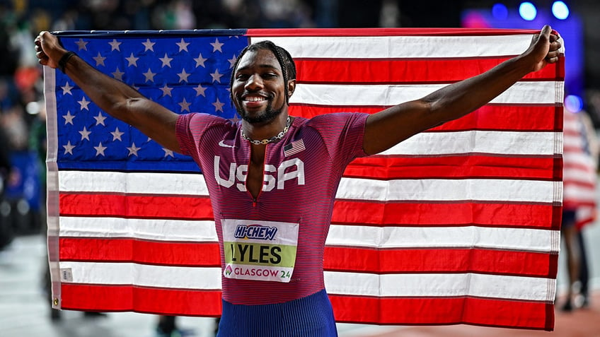 Noah Lyles holding American flag