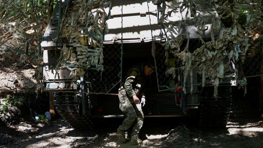 A Ukrainian serviceman walks next to a Panzerhaubitze 2000 self-propelled howitzer after firing toward Russian troops, amid Russia's attack on Ukraine