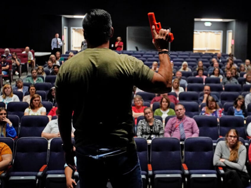 PROVO, UT - SEPTEMBER 04: Dave Acosta, founder of Fight Back holds a dummy handgun as he t