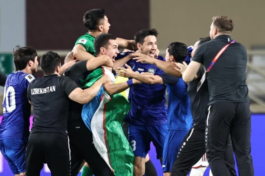 Uzbekistan's players celebrate after booking their berth in the FIFA World Cup for the fir