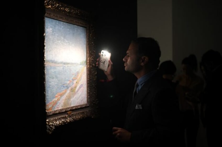 A visitor looks closely at 'Les canots amarres' by Vincent van Gogh at Christie's new Asia