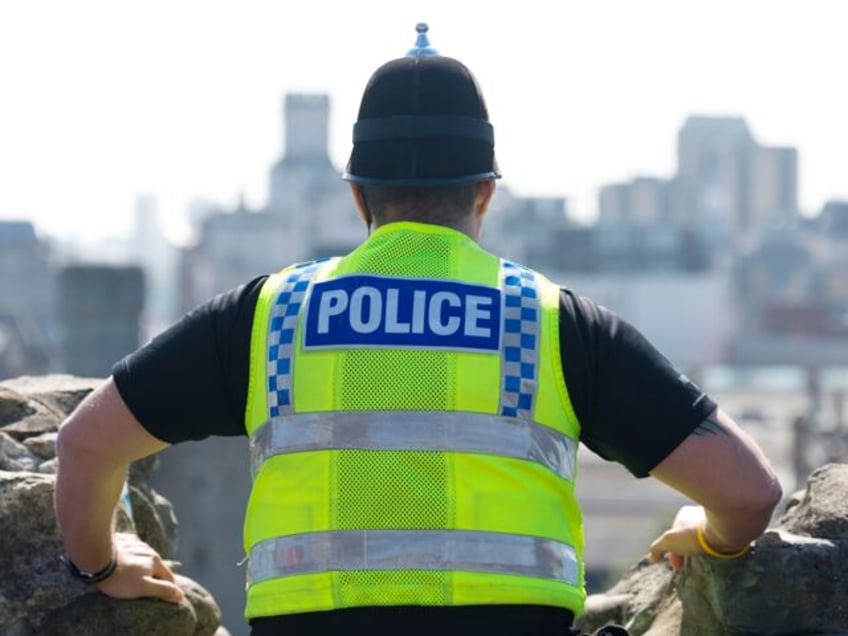 CARDIFF, WALES - SEPTEMBER 02: A police officer looks over the city from Cardiff Castle as