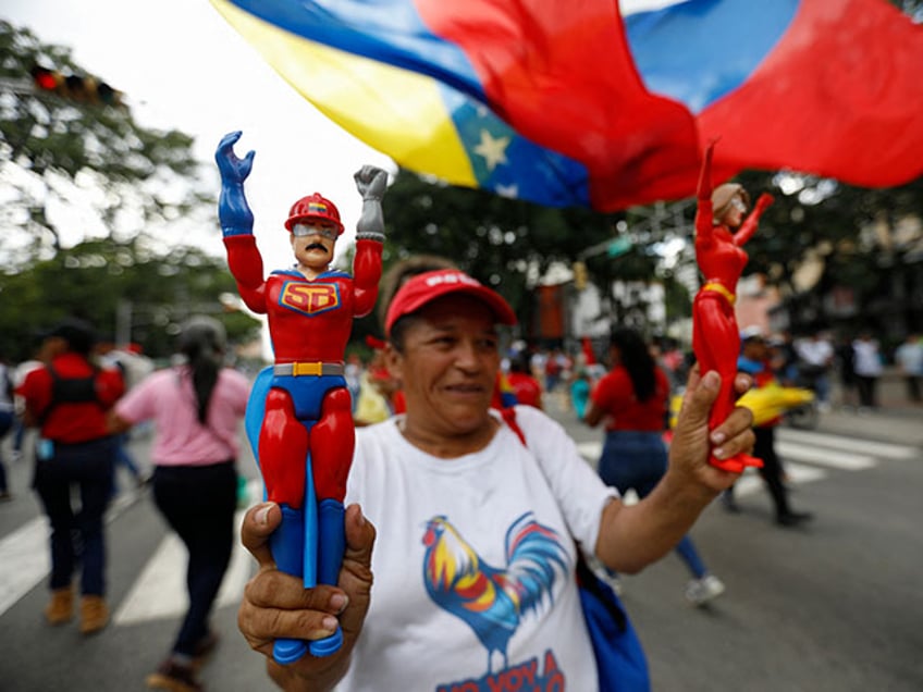 A supporter of President Nicolas Maduro holds a dummy of the character known as "Super Bigote," which represents Maduro, as she takes part in a march to defend the Law against Fascism, Neofascism and Similar Expressions in Caracas on August 23, 2024. The United States, along with countries in Europe and Latin America, on Friday rejected the certification by Venezuela's Supreme Court of strongman Nicolas Maduro's widely questioned presidential reelection. (Photo by Pedro Rances Mattey / AFP) (Photo by PEDRO RANCES MATTEY/AFP via Getty Images)