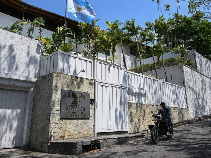 A motorcyclist rides past the residence of Argentina's ambassador in Caracas on March